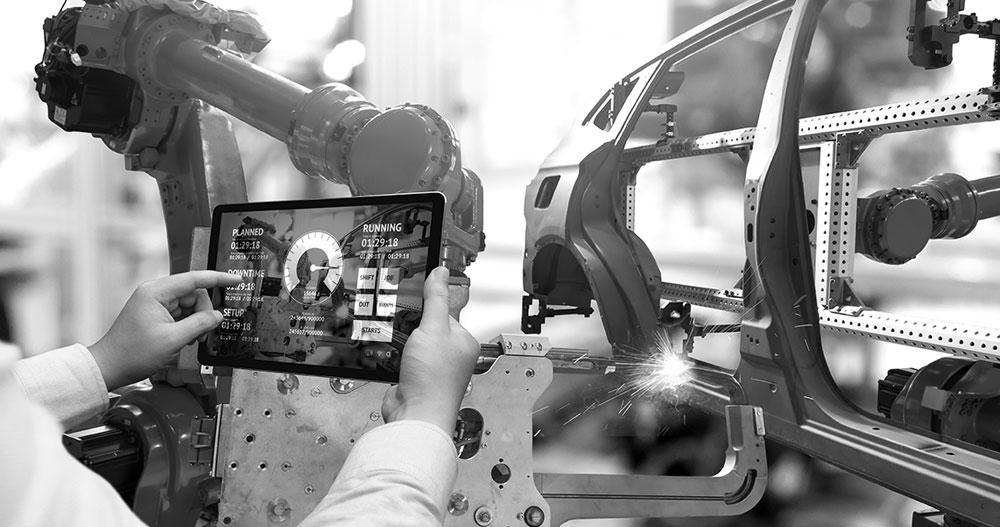 Persona viendo una tablet de rendimiento vehicular en una planta de producción automotriz