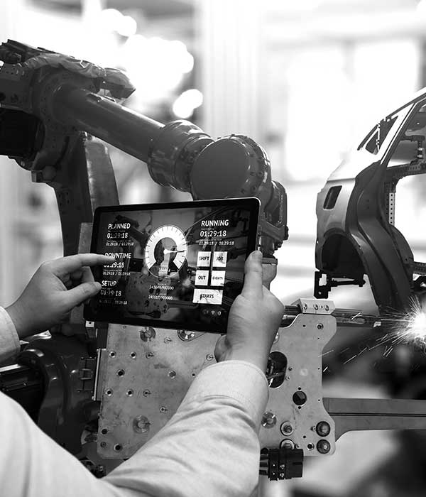 Persona sosteniendo tableta con información tecnológica sobre la fabricación de un auto
